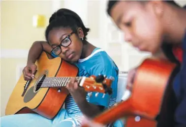  ?? STAFF PHOTO BY ERIN O. SMITH ?? Zaria Spight, 11, works on chords during a lesson through the Unity Performing Arts Foundation.