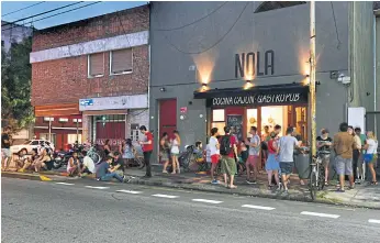  ??  ?? A crowd outside Nola, a gastro pub that serves Louisiana specialiti­es.