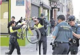  ?? ?? Policías locales cogen la bicicleta que conducía la víctima mortal.