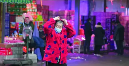  ?? AP ?? Una mujer delante del mercado de Huanan, donde ahora parece que no tiene nada que ver con la propagació­n del virus