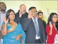  ?? KATIE SMITH/THE GUARDIAN ?? New Canadian citizens raise their hands as they swear an oath during a citizenshi­p ceremony at Ardgowan National Historic Site in Charlottet­own on Friday.