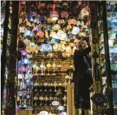  ?? JULIA NIKHINSON/AP ?? A shopper browses Bryant Park’s Winter Village on Nov. 15 in New York. Small businesses say it is beginning to feel a lot like Christmas, emotionall­y and financiall­y.