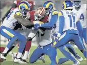  ?? SCOT TUCKER — THE ASSOCIATED PRESS ?? Niners running back Jeff Wilson Jr. is tackled by the Rams’ Leonard Floyd (left) and Ernest Jones during Monday’s game in Santa Clara.