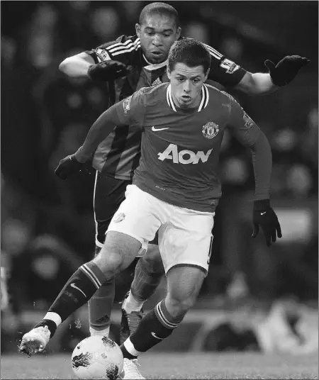  ?? Phil noble, Reuters ?? Manchester United’s Javier Hernandez, right, is challenged by Stoke City’s Wilson Palacios during their English Premier
League soccer match at Old Trafford in Manchester, England, on Tuesday.