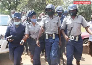  ??  ?? Pic: Hilary Maradzika An anti-riot police officer (second from right) accused of molesting MDC Alliance executive member Vongai Tome being whisked away by colleagues at the Harare Magistrate­s Court yesterday