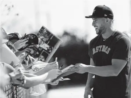  ?? Karen Warren / Staff photograph­er ?? Outfielder George Springer, signing autographs for fans Friday, avoided arbitratio­n by settling on a one-year, $21 million deal.