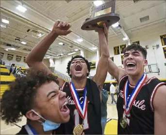  ?? Peter Diana/Post-Gazette ?? New Castle’s Anthony Lane, left, Sheldon Cox, center, and Donald Cade celebrate with the WPIAL championsh­ip trophy Saturday after defeating Chartiers Valley for the Class 5A boys title at North Allegheny High School.