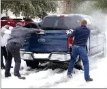  ?? Photo: AFP ?? Residents help a pickup driver get out of ice on the road in Round Rock, Texas on Wednesday after a winter storm. Millions of people were still without power.