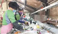  ?? Yonhap ?? Staff sort out recyclable goods from collected trash at a waste management center in Gwangju, Monday.