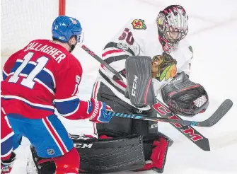  ?? GRAHAM HUGHES, THE CANADIAN PRESS ?? Blackhawks goalie Corey Crawford makes a glove save with Canadiens forward Brendan Gallagher in close during the first period in Montreal on Tuesday.