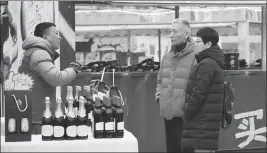  ?? LI YIBO / XINHUA ?? Residents in Xi’an, Shaanxi province, shop for foreign wines imported via the China-Europe freight rail links in January.