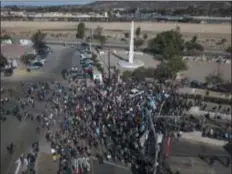  ?? RODRIGO ABD/ASSOCIATED PRESS ?? A group of migrants gather at the Chaparral border crossing in Tijuana, Mexico, on Nov. 25, as they try to pressure their way into the U.S.