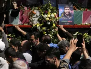  ?? Vahid Salemi/Associated Press ?? Iranian mourners try to touch the flagdraped coffins of Revolution­ary Guard members killed in an airstrike widely attributed to Israel that destroyed Iran's Consulate in Syria on Monday, in a funeral procession Friday in Tehran, Iran.