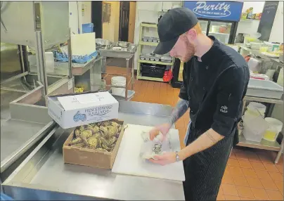  ?? BRADLEY COLLINS/THE GUARDIAN ?? Brennan Roy, cook at the Pilot House Restaurant, shucks a fresh oyster from Prince Edward Aqua Farms. Atlantic oyster sales have seen a dramatic increase with the outbreak of norovirus in West Coast oysters