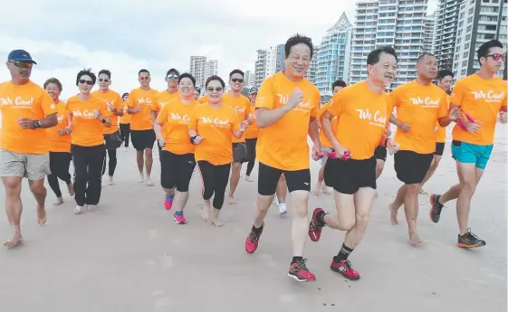  ?? Picture: MIKE BATTERHAM ?? The Fearless Dragons, a blind and deaf running group from Hong Kong, warm up for the marathon on Surfers Paradise beach.