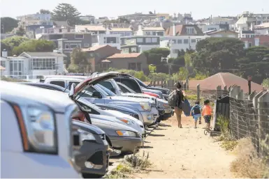  ?? Photos by Santiago Mejia / The Chronicle ?? Top: The Baker Beach parking lot in San Francisco filled up, and temperatur­es are expected to rise over the weekend.