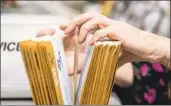  ?? Nick Agro For The Times ?? A WORKER at the Orange County registrar of voters office sorts through mail-in ballots.