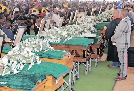  ?? SHANELL DANIEL ?? FOURTEEN coffins lined up in a row at the mass funeral that was held at Waterbus Sports Ground in Pongola (held) yesterday for victims of the fatal crash that took 20 lives on the N2 last week. . |