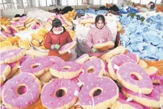  ??  ?? Chinese employees making toys for export at a factory in Lianyungan­g in east China’s Jiangsu province. China’s factory inflation slowed to a 13-month low in December 2017, official data showed on January 10, a sign of continued fragility in the world’s...