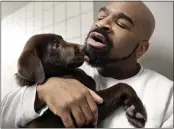  ?? ELISE AMENDOLA — THE ASSOCIATED PRESS ?? inmate Jonathan Ladson cuddles with a chocolate Labrador puppy at Merrimack County jail in Boscawen, N.H.