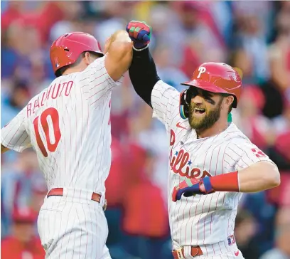  ?? MATT ROURKE/AP ?? Phillies designated hitter Bryce Harper, right, celebrates his two-run home run with J.T. Realmuto during Game 3 of the NLDS against the Braves on Oct. 14 in Philadelph­ia.