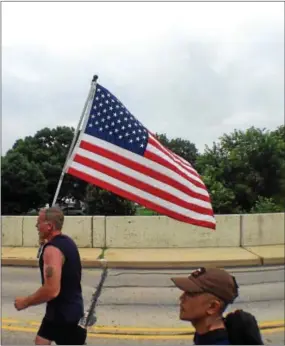  ?? ADAM FARENCE — DAILY LOCAL NEWS ?? Markus Ismael, Al Yusko, and Chris Mazzoli took turns holding the American flag and wearing a twenty pound backpack during the 15K race at Good Neighbor Day.