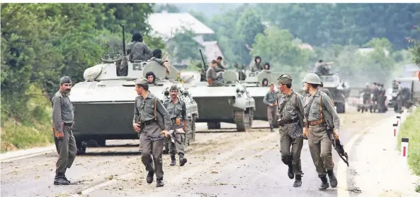  ?? FOTO: JOEL ROBINE/AFP ?? Jugoslawis­che Truppen bereiten sich im Sommer 1991 von ihrer Position an der kroatisch-slowenisch­en Grenze auf ihren Einmarsch in Slowenien vor.