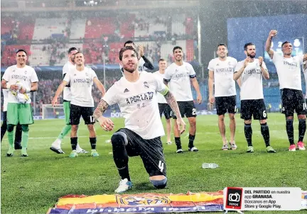  ?? JUANJO MARTIN / REUTERS ?? Celebració­n. Los jugadores del Real Madrid fueron hasta la zona de la hinchada visitante con una camiseta especial que anuncia que van por su duodécima estrella europea.