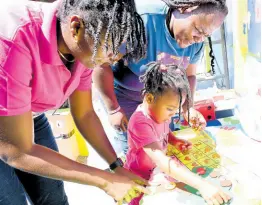  ?? ?? Student Akena Gordon (centre) counts numbers with her mother and teacher Aneska Archer (left) and Tansea Maitland-Tomlin, teacher at Seaward Primary and Infant, during Internatio­nal Mathematic­s Day, held under the theme ‘Playing with Math’ at the Seaward Primary and Infant School in Kingston yesterday.