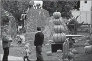  ?? SARAH GORDON/THE DAY ?? From left, Amy Kittelsen, with her granddaugh­ter Jessica Gomez, 2, and girlfriend Mandy Mabe, all of Winsted, walk along the path at the Pumpkin Palace.