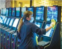  ?? HARTFORD COURANT ?? A casino worker cleans kiosks at Mohegan Sun prior to a ceremony marking opening day for sports betting in Connecticu­t in 2021.