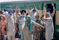  ?? AFP ?? Indian Sikh pilgrims cheer as they arrive at Wagah Railway Station in Lahore on Friday. —