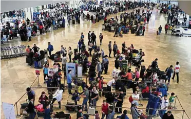  ?? — Reuters ?? Expansion project: A file picture showing passengers waiting for their flights inside the Ninoy Aquino Internatio­nal Airport (NAIA) terminal 1 in Manila. Two groups have submitted proposals to upgrade and expand the airport.