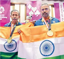  ??  ?? Gold medallist India’s Pranab Bardhan and Shibhnath Sarkar pose with the Indian tricolour after winning in bridge competitio­n at the 18th Asian Games in Jakarta on Saturday