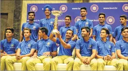  ??  ?? India Under-19 team members with the World Cup trophy during a news conference in Mumbai on Monday.