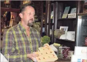 ?? Doug Walker / Rome News-Tribune ?? Curtis Burch shows a customer some caramel fudge in The Peddler store, 22 Alabama St.