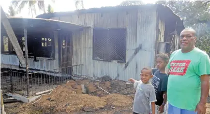  ??  ?? Vero Weresili Tonini with his daughter Katarina Sau and his grandson Mikaele Rajale Junior standing in front of their burnt house at Korociri in Nadi yesterday.