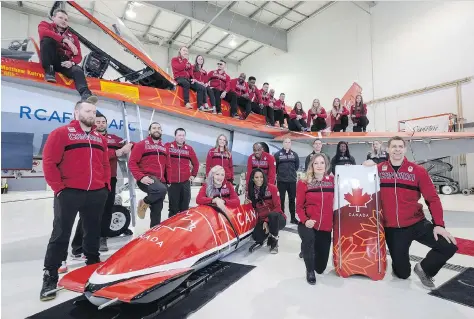  ?? JEFF MCINTOSH/THE CANADIAN PRESS ?? Athletes named to the Canadian Olympic bobsled and skeleton teams, including Ben Coakwell from Moose Jaw, stand on and sit in front of a Canadian Forces CF-18 after the naming of the teams in Calgary on Wednesday.