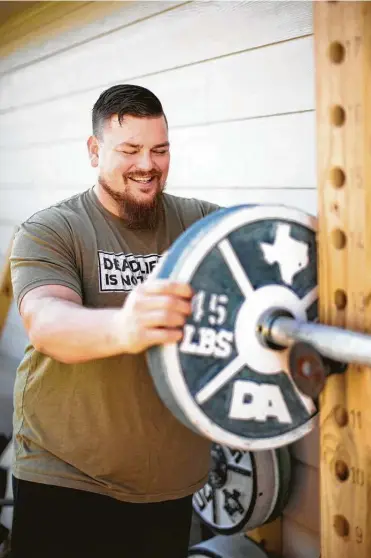  ??  ?? David Accardo, creator of plate molds for concrete weights, stands with his wares at his home gym in Friendswoo­d.