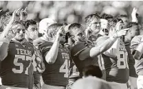  ?? Tim Warner / Getty Images/ TNS file photo ?? University of Texas football players stand for “The Eyes of Texas” after a game last November in Austin.