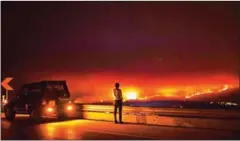  ?? PATRICIA DE MELO MOREIRA/AFP ?? A man stands on the roadside watching a wildfire at Anciao, Leiria, central Portugal, yesterday.