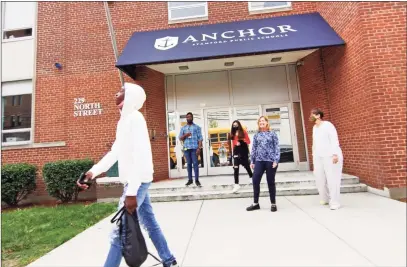  ?? Christian Abraham / Hearst Connecticu­t Media ?? Anchor School Director Laura Greene, in back center, watches as some of her students board the bus in front of the school’s new location on North Street in Stamford on Wednesday.