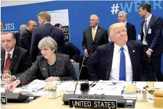  ?? Thierry Charlier/Pool Photo via AP ?? U.S. President Donald Trump, right, smiles as he sits next to Britain’s Prime Minister Theresa May, center, and Turkish President Recep Tayyip Erdogan as they participat­e in a working dinner meeting during the NATO summit of heads of state and...