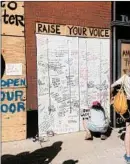  ?? CHICAGO TRIBUNE ?? Members of Chicago’s theater community sign boards that were placed over the doors to the Victory Gardens Theater.