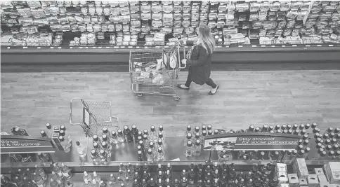  ??  ?? A woman shops at a Kroger grocery store in Birmingham, Michigan.