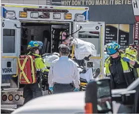  ?? AARON VINCENT ELKAIM THE CANADIAN PRESS ?? A injured person is put into the back of an ambulance in Toronto after a van mounted a sidewalk crashing into a number of pedestrian­s.