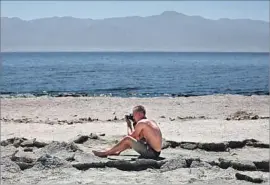  ??  ?? TAY PATTISON of San Diego photograph­s his mother, Christine Todd, at the Salton Sea State Recreation Area in Mecca, Calif., in August.