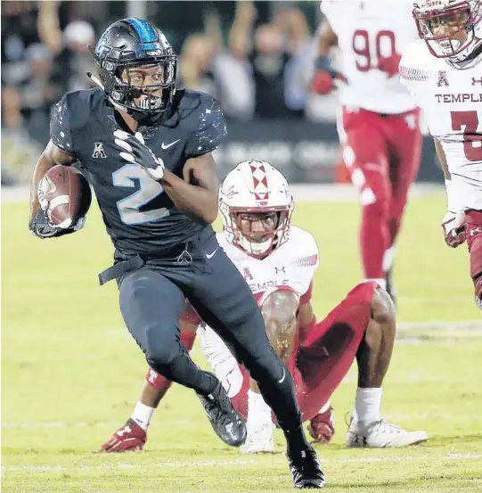  ?? STEPHEN M. DOWELL/ORLANDO SENTINEL PHOTOS ?? UCF wide receiver Otis Anderson pulls away from Temple defenders during the Knights’ critical game against the Owls on Thursday night at Spectrum Stadium.