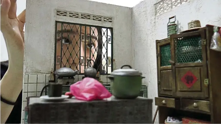  ?? — Photos: IAN OH/ The Star ?? Lim attaching a miniature canopy on her kitchen set, which is 12 times smaller than the original. The kitchen comes with a wooden cupboard, a countertop, peranakan tiles and an old rice cooker.