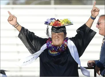  ?? PHOTOS BY JOEL ROSENBAUM — THE REPORTER ?? Muzetta Thrower Adult Education Center graduate Jennifer Marie Lacson Victoria celebrates as she walks across the stage to the cheers of her family to receive her diploma during commenceme­nt ceremonies Wednesday at Wildcat Stadium.